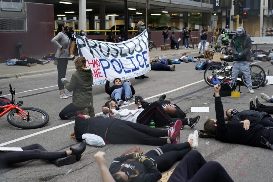 Protesters hold a die-in outside the Hennepin County Family Justice Center where four former Minneapolis police officers appeared at a hearing Friday, Sept. 11, 2020, in Minneapolis. The officers are charged in the death of George Floyd who died in police custody in May.