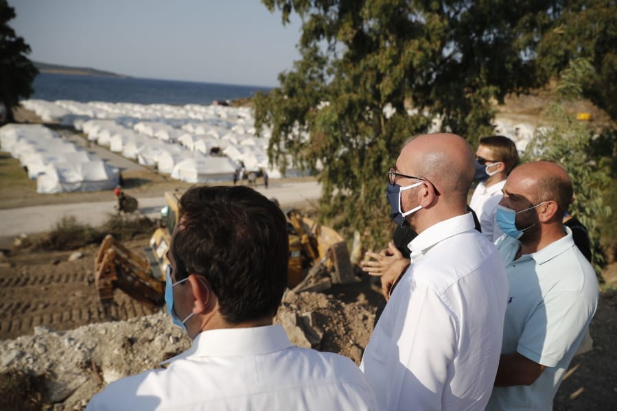 European Council President Charles Michel, center, accompanied by Greek officials, looks at the new temporary refugee camp in Kara Tepe during his visit on the northeastern island of Lesbos, Greece, Tuesday, Sept. 15, 2020.