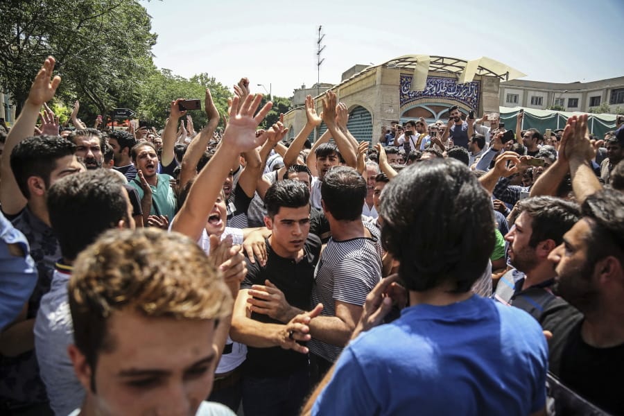 FILE - In this June 25, 2018 file photo, a group of protesters chant slogans at the main gate of the Old Grand Bazaar, in Tehran, Iran. On Saturday, Sept. 5, 2020, Iran broadcast the televised confession of a wrestler facing the death penalty after a tweet from President Donald Trump criticizing the case, a segment that resembled hundreds of other suspected coerced confessions aired over the last decade in the Islamic Republic. The case of 27-year-old Navid Afkari has drawn the attention of a social media campaign that portrays him and his brothers as victims targeted over participating in protests against Iran&#039;s Shiite theocracy in 2018.