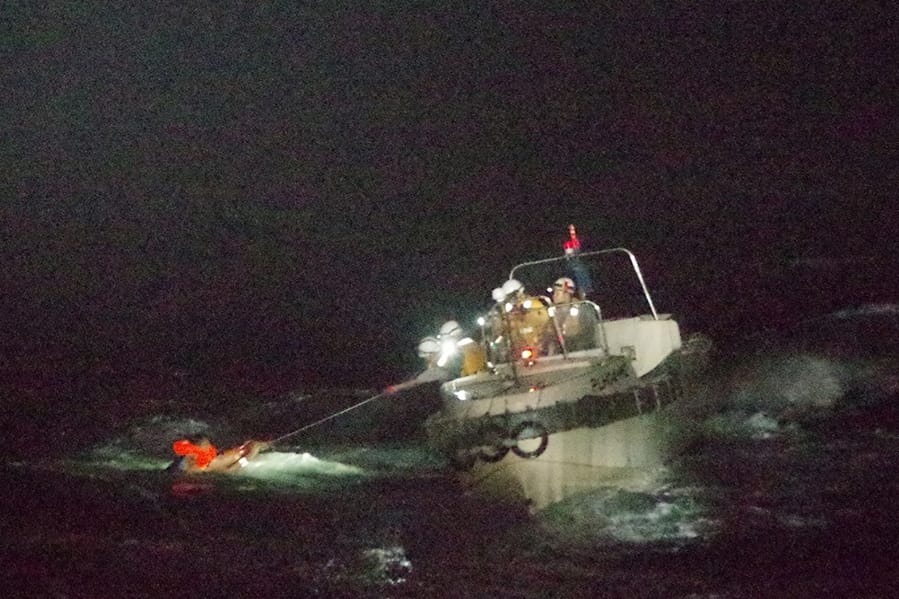 In this photo released by the 10th Regional Japan Coast Guard Headquarters, a Filipino crewmember of a Panamanian cargo ship is rescued by Japanese Coast Guard members in the waters off the Amami Oshima, Japan Wednesday, Sept. 2, 2020. Japanese rescuers have safely plucked the crewmember from the sea while searching for the cargo ship carrying more than 40 crew and thousands of cows went missing after sending a distress call off the southern Japanese island.