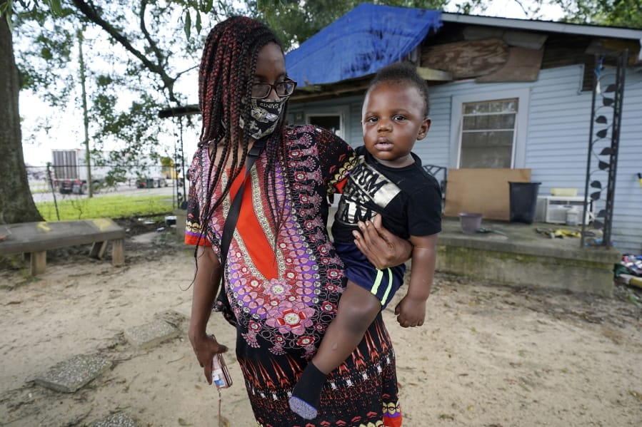 Fakisha Fenderson and her son Tyler stand in the front yard of her parent&#039;s home in Laurel, Miss., Monday, Aug. 31, 2020. Fenderson&#039;s weekly unemployment allotment is under $100, effectively eliminating her chance at receiving the $300 weekly supplement proposed by President Trump&#039;s executive order. (AP Photo/Rogelio V. Solis) (rogelio v.
