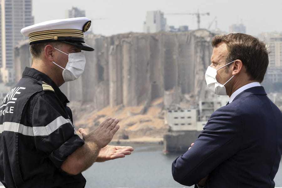 Arnaud Tranchant, left, chief Navy officer for the French helicopter carrier Tonnerre, talks to French President Emmanuel Macron off the port of Beirut, Tuesday, Sept.1, 2020. The visit was Emmanuel Macron&#039;s second since the devastating Aug. 4 explosion -- the most destructive single incident in Lebanon&#039;s history -- that killed at least 190 people .