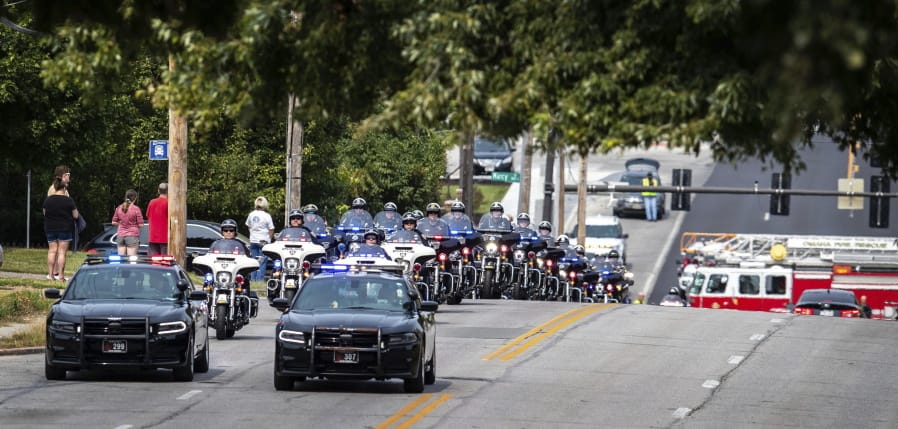 People stand out on 42nd Street north of Pacific street to watch as Omaha police officers escort the body of Lincoln police officer Mario Herrera back to Lincoln after he died on Monday, Sept. 7, 2020. Herrera was shot Aug. 26 while trying to serve a warrant.