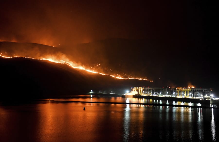 Flames from the Cold Springs Canyon Pearl Hill wildfire encroach on Wells Dam, Monday, Sept. 7, 2020, near Azwell, Wash.