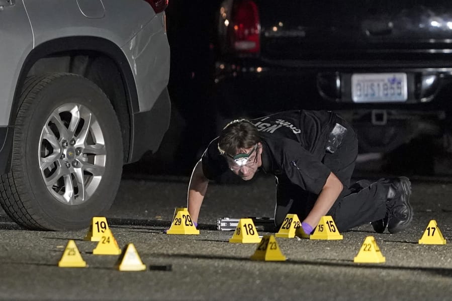 A Washington State Patrol Crime Lab worker looks at evidence markers in the early morning hours of Sept. 4 in Lacey, at the scene where Michael Reinoehl was killed as investigators moved in to arrest him. (Ted S.