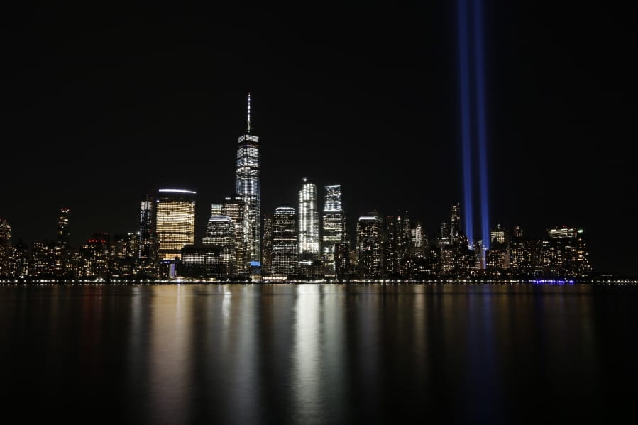 FILE - In this Sept. 11, 2017, file photo, the Tribute in Light illuminates in the sky above the Lower Manhattan area of New York, as seen from across the Hudson River in Jersey City, N.J. The coronavirus pandemic has reshaped how the U.S. is observing the anniversary of 9/11. The terror attacks&#039; 19th anniversary will be marked Friday, Sept. 11, 2020, by dueling ceremonies at the Sept. 11 memorial plaza and a corner nearby in New York.
