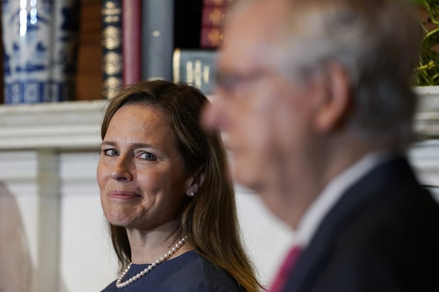 Supreme Court nominee Judge Amy Coney Barrett looks over to Senate Majority Leader Mitch McConnell of Ky., as they meet with on Capitol Hill in Washington, Tuesday, Sept. 29, 2020.