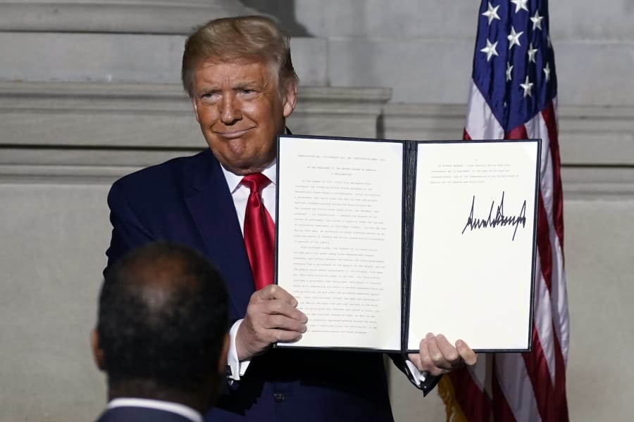 President Donald Trump holds a signed Constitution Day proclamation after he spoke to the White House conference on American History at the National Archives museum, Thursday, Sept. 17, 2020, in Washington.
