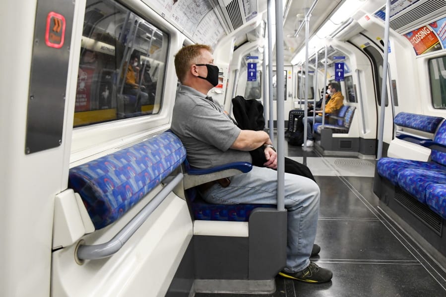 A man wears a face mask to protect against infection from coronavirus as he sits on an Underground train, in London, Tuesday, Sept. 8, 2020.