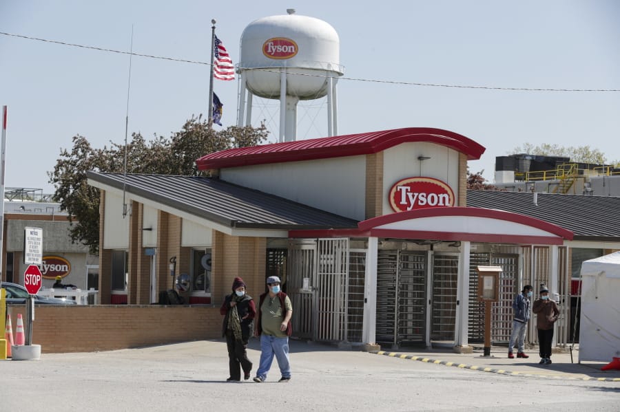 FILE - In this May 7, 2020, file photo, workers enter and leave the Tyson Foods pork processing plant in Logansport, Ind. Tyson Foods is planning to open medical clinics at several of its U.S. plants to improve the health of workers at the same time it is under pressure to better protect them from the coronavirus.