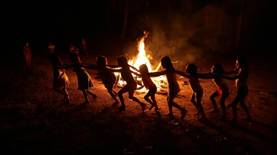 Tenetehara Indigenous children play around a campfire during a festival in the Alto Rio Guama Indigenous Reserve, where they have enforced six months of isolation during the new coronavirus pandemic, near the city of Paragominas, Brazil, Monday, Sept. 7, 2020. The Indigenous group, also known as Tembe, are celebrating and giving thanks that none of their members have fallen ill with COVID-19.