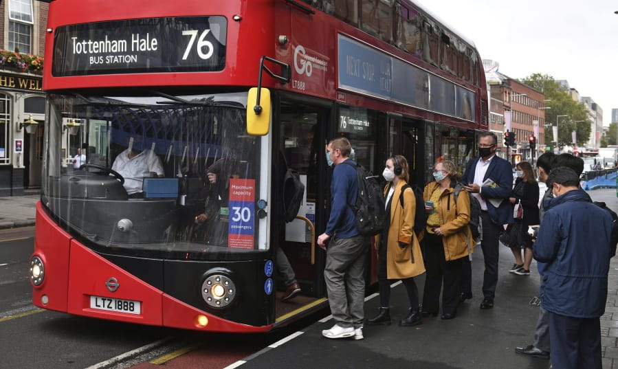 People board a bus outside Waterloo station in London, Wednesday, Sept. 23, 2020, after Prime Minister Boris Johnson announced a range of new restrictions to combat the rise in coronavirus cases in England, Wednesday, Sept. 23, 2020.