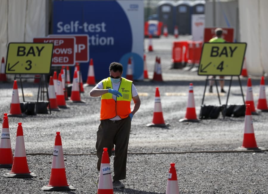 A staff member waits at empty lanes of a Covid-19 drive thru testing facility at Twickenham stadium in London, Thursday, Sept. 17, 2020. Britain has imposed tougher restrictions on people and businesses in parts of northeastern England on Thursday as the nation attempts to stem the spread of COVID-19, although some testing facilities remain under-utilised.