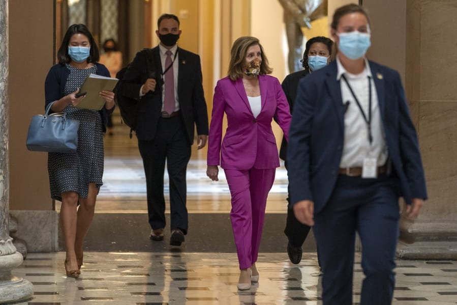 House Speaker Nancy Pelosi of Calif., center, walks to her office, Monday, Sept. 14, 2020, on Capitol Hill in Washington.