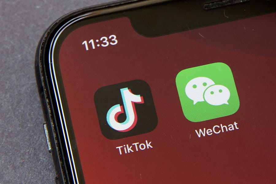 FILE - Icons for the smartphone apps TikTok and WeChat are seen on a smartphone screen in Beijing, in a Friday, Aug. 7, 2020 file photo.  The Commerce Department said President Trump&#039;s proposed ban of the apps WeChat and TikTok will go into effect Sunday, Sept.
