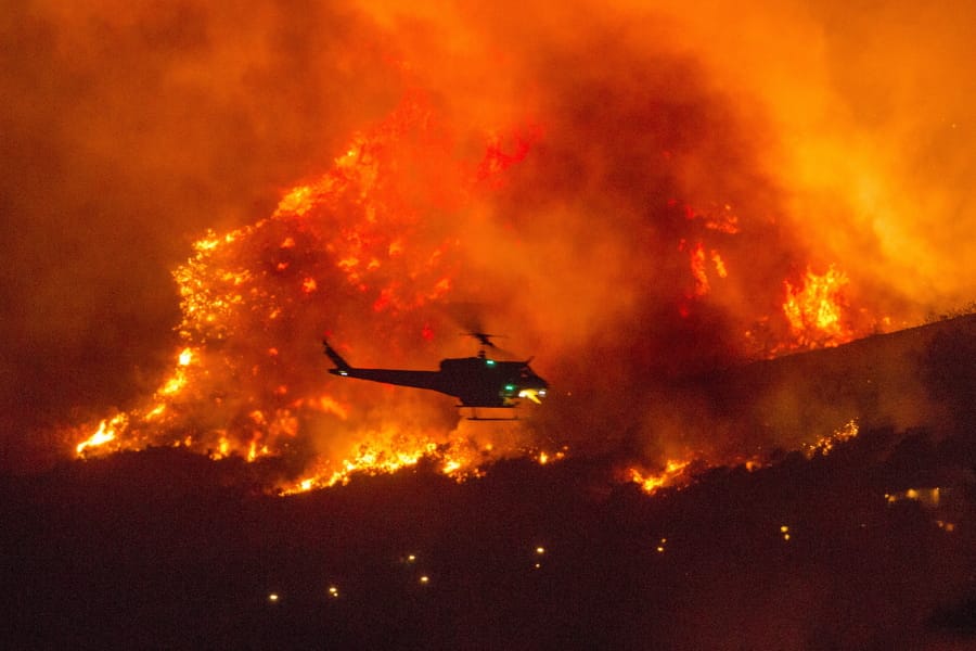 A helicopter prepares to drop water at a wildfire in Yucaipa, Calif., Saturday, Sept. 5, 2020. (AP Photo/Ringo H.W.