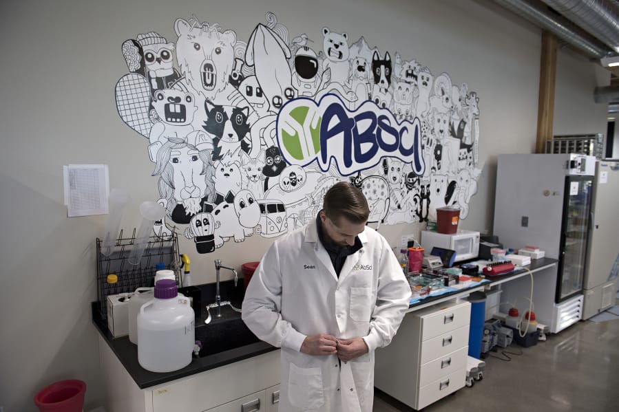 Sean McClain, founder and CEO of AbSci in downtown Vancouver, prepares his lab coat before pausing for a portrait in his company&#039;s lab. The company is preparing to start construction on a 60,000-square-foot building in Vancouver to house all operations and employees, according to McClain.
