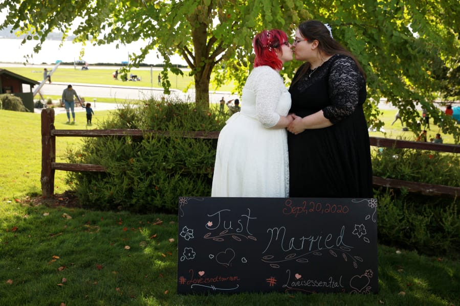 Sara Morosan, left, and her wife Allyssa Howard kiss after their wedding at Peace Arch State Park on the border between the United States and Canada in Blaine, Washington on Sunday, September 20, 2020. With the park crowded with couples and families meeting, Howard, of Lake Stevens, Washington, and Morosan, of Chilliwack, British Columbia, married in a small corner of the park near a garden and fence that separates the two countries.