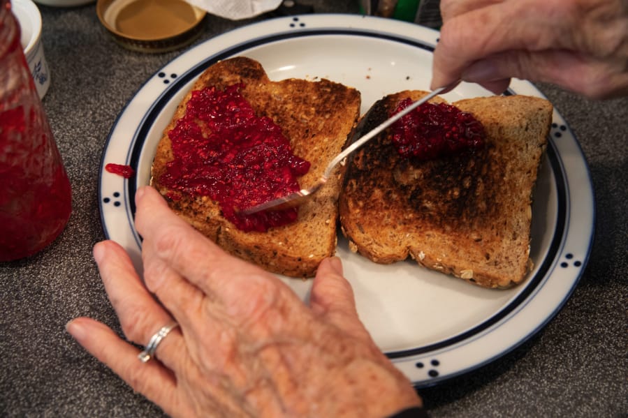 Gloria Witt spreads her homemade raspberry jam on toast she just made from a toaster she and her husband Frank received as a wedding gift 71 years ago. When looking at the piece of toast at right, she said that it was still a good toaster, the bread was just a tiny bit burnt. (Ellen M. Banner/The Seattle Times/TNS) (Ellen M.