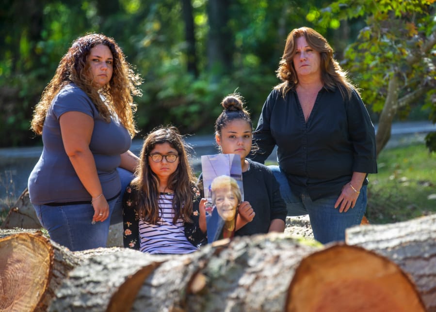 Tyffani Murillo, her daughters Rylie Dickinson, 9, and Emmie Dickinson, 12, with their grandmother Kareen Huffman are photographed near some freshly cut trees on Huffman&#039;s property in Lake Stevens. The young granddaughters are holding a photograph of their great grandma Darlene Mach who passed away earlier this year at the age of 83. The girls great-great grandmother, Kathleen Chappell died last year at the age of 103. Photographed on September 22, 2020.