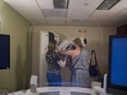 Radiological technologist Jenni Barr, left, assists Amy Libby while she gets her first mammogram at Kaiser Permanente&#039;s Cascade Park office in August.