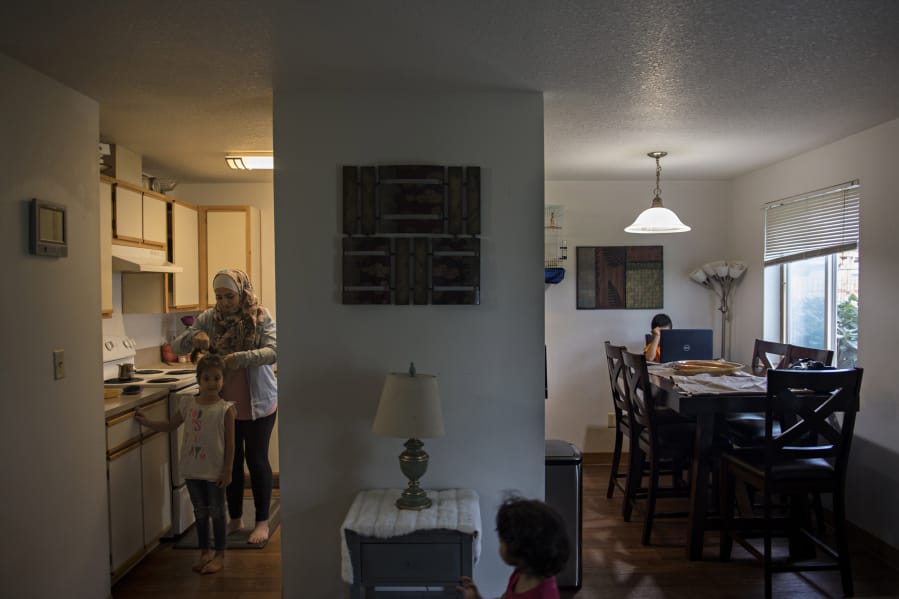 Sham Nawras, 6, prepares for a new school day with the help of her mom, Nour Alkafaween, while joined by her sister, Taj Nawras, 2, and her brother, Saif Nawras, 8, in their Vancouver apartment Monday morning.
