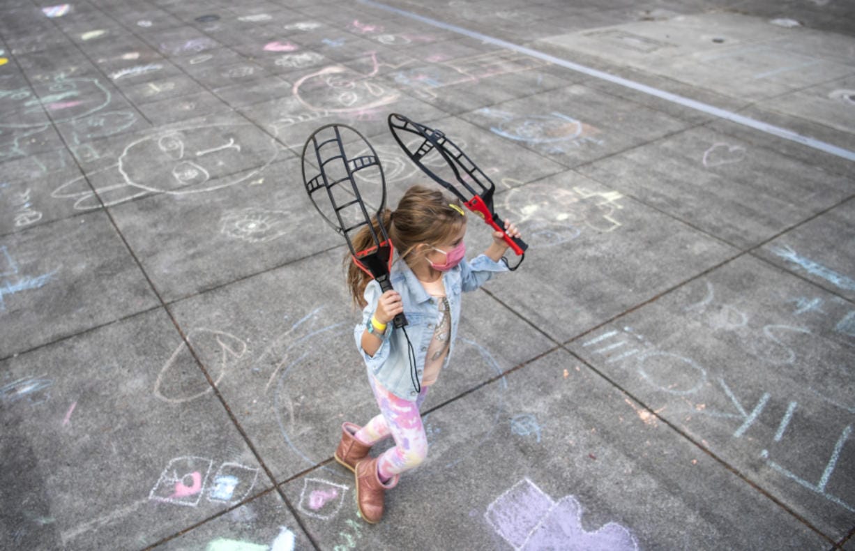 Lylah Bloom, 6, plays outside during the after-school program at Firstenburg Community Center in Vancouver. Below, Cash Mendoza, 6, sports a cat mask at the after-school program at Firstenburg Community Center in Vancouver.