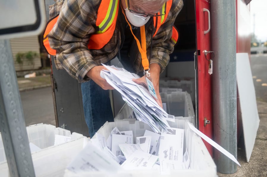 Elections worker John Waterbury collects ballots from an official ballot drop box Saturday in downtown Vancouver.
