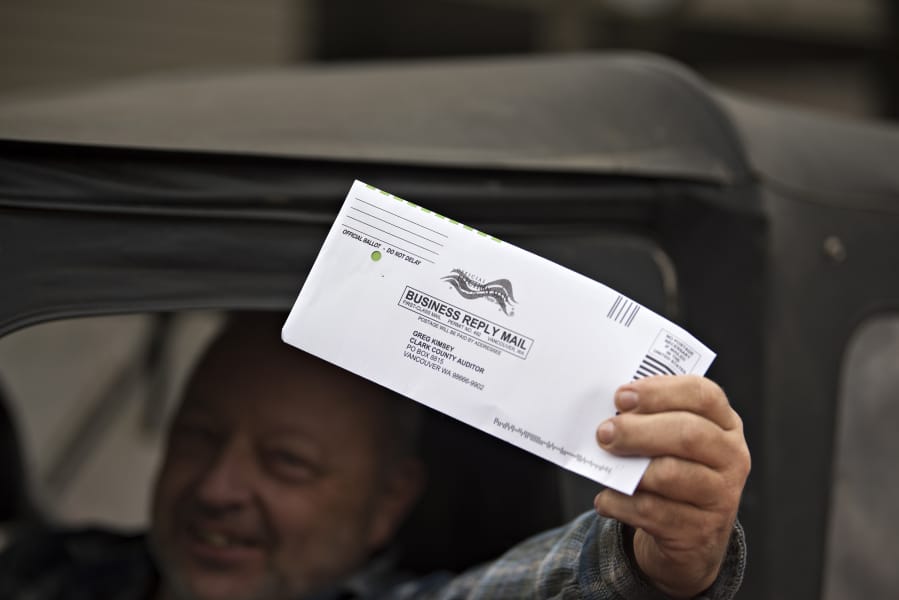 Vancouver resident Larry Hellstrom displays his ballot before dropping it off Thursday afternoon in downtown Vancouver.