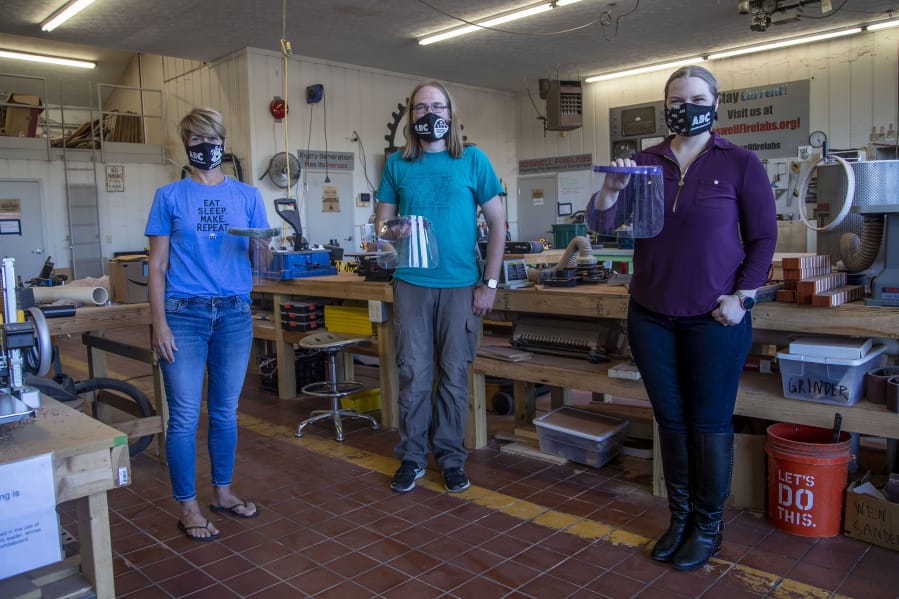 Irm Diorio (left), director of Decatur Makers, William Strika (center), executive director of Roswell Firelabs and Skyler Holobach (right), co-founder of Atlanta Shield Makers, pose with face shields they created on Tuesday, Oct. 6, 2020 at Roswell Firelabs in Roswell, Georgia.
