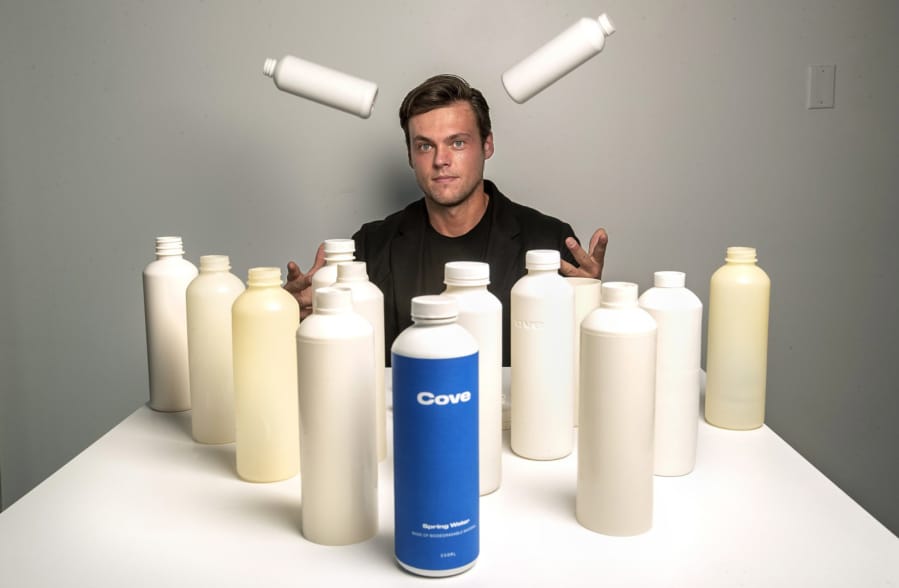 Alex Totterman, CEO and founder of Cove Water in Culver City, Calif., is photographed on Oct. 2, 2020 with a mix of prototype and actual plastic water bottles, as well as bottle caps and label that he says are made up entirely of biodegradable material. The company will begin selling the bottled water sometime in the fall.