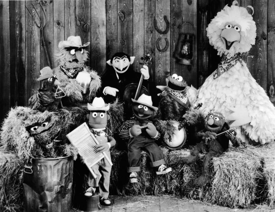 Publicity still of the Sesame Street Muppets taken to promote their record album, &#039;Sesame Country,&#039; July 1, 1981. Included are Oscar the Crouch (in garbage can), Bert (holding washboard), Ernie (harmonica), the Count (bass), Cookie Monster (banjo), Grover (violin), and Big Bird (far right).