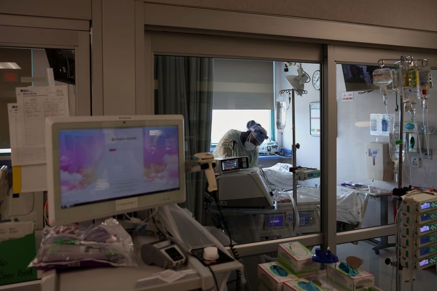 A medical worker works inside a patient room in a COVID-19 intensive care unit at Temple University Hospital&#039;s Boyer Pavilion in North Philadelphia on Tuesday, April 7, 2020.