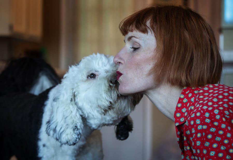 Bunny, a 14-month old sheepadoodle, and her owner Alexis Devine, share a kiss in their Tacoma home Tuesday, Sept. 29, 2020. Devine, an artist in Tacoma, is teaching her dog Bunny to communicate with buttons. (Ellen M. Banner/The Seattle Times/TNS) (Photos by Ellen M.