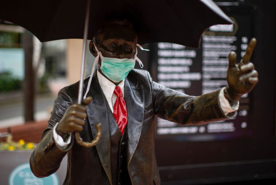 The &quot;Umbrella Man&quot; statue in downtown Portland&#039;s Pioneer Square wears a face mask in April.