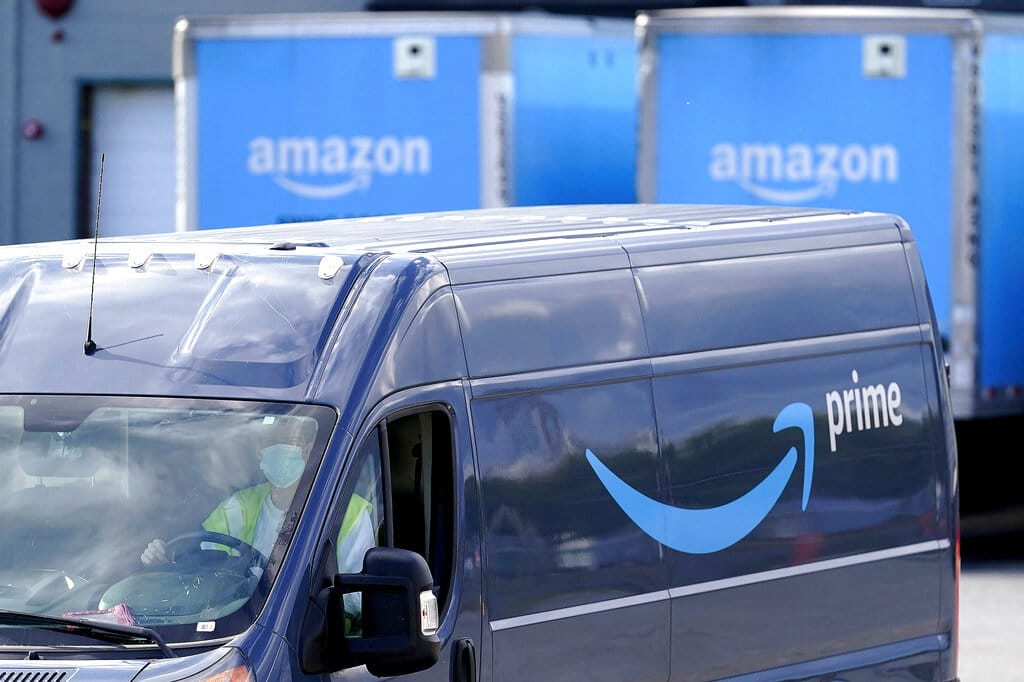An Amazon Prime logo appears on the side of a delivery van as it departs an Amazon Warehouse location, Thursday, Oct. 1, 2020, in Dedham, Mass. Halloween is still weeks away, but retailers are hoping you’ll start your holiday shopping now. The big push is coming from Amazon, which is holding its annual Prime Day sales event Tuesday, Oct. 13 and Wednesday, Oct. 14.