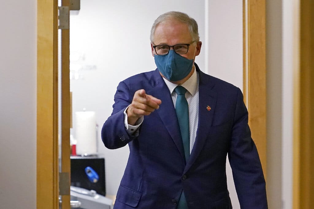 Washington Gov. Jay Inslee, a Democrat, points to a member of his team after taking part in a debate with Loren Culp, a Republican, Wednesday, Oct. 7, 2020, in Olympia, Wash. Due to concerns over COVID-19, each candidate took part in the debate from an individual room, separate from moderators. (AP Photo/Ted S.