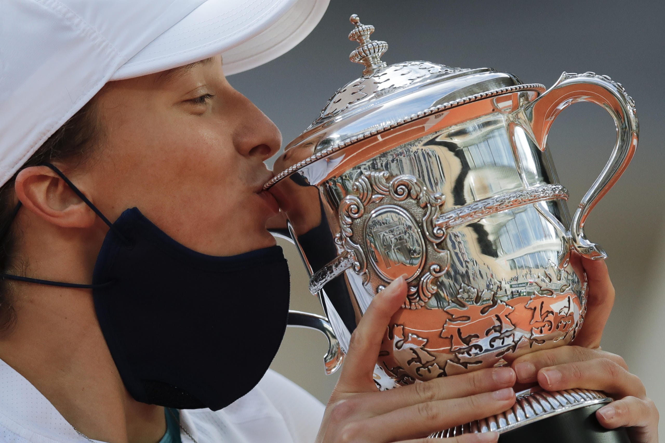 Poland's Iga Swiatek kisses the trophy after winning the final match of the French Open tennis tournament against Sofia Kenin of the U.S. in two sets 6-4, 6-1, at the Roland Garros stadium in Paris, France, Saturday, Oct. 10, 2020.