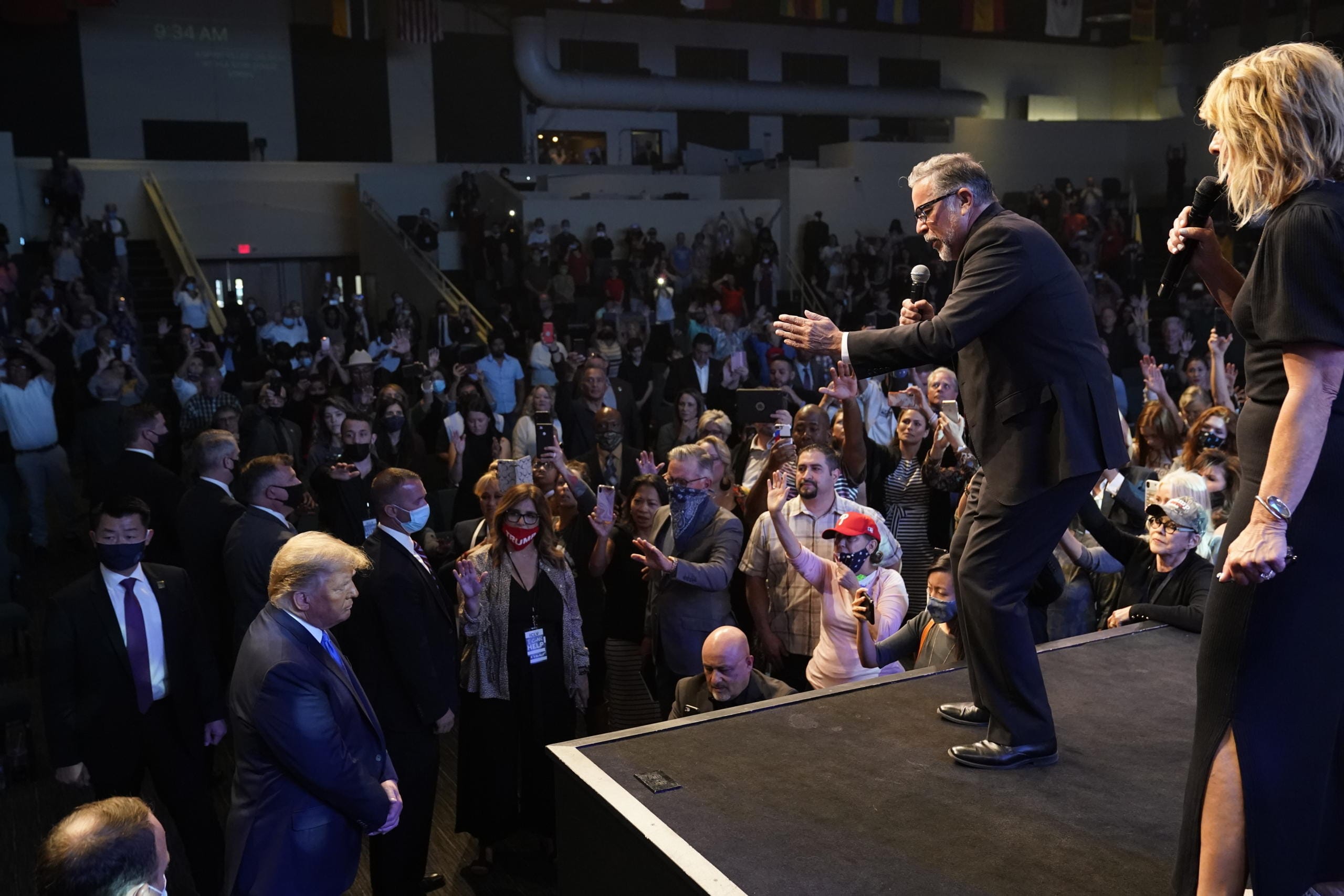 President Donald Trump, lower left, attends church at International Church of Las Vegas, as Pastor Pasqual Urrabazo, second from the right, gestures on stage, Sunday, Oct. 18, 2020, in Las Vegas, Nev.