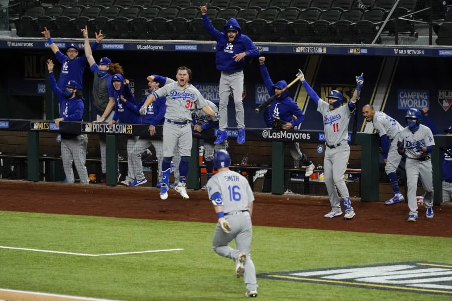 The Los Angeles Dodgers celebrate a three-run home run by Will Smith against the Atlanta Braves during the sixth inning in Game 5 of a baseball National League Championship Series Friday, Oct.