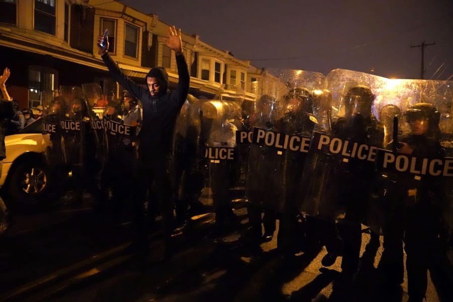 Sharif Proctor lifts his hands up in front of the police line during a protest in response to the police shooting of Walter Wallace Jr., Monday, Oct. 26, 2020, in Philadelphia. Police officers fatally shot the 27-year-old Black man during a confrontation Monday afternoon in West Philadelphia that quickly raised tensions in the neighborhood.