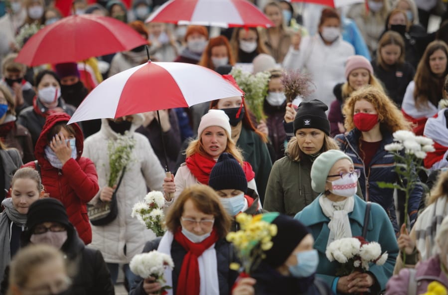 Women with umbrellas in the colors of the old Belarusian national flag take part in a rally Saturday to protest the official presidential election results in Minsk, Belarus.