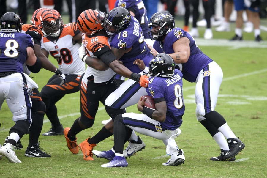 Cincinnati Bengals defensive end Carlos Dunlap (96) is able to sack Baltimore Ravens quarterback Lamar Jackson (8) in spite of being blocked by Ravens offensive tackle Orlando Brown (78) during the first half of an NFL football game, Sunday, Oct. 11, 2020, in Baltimore.