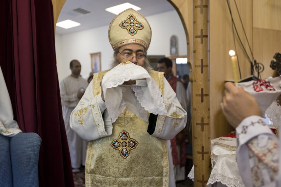 In this Sunday, Aug. 18, 2013 photo, Father Reweis Khalil brings the bread (Body of Christ) to worshippers during Sunday service at St. George Coptic Orthodox Church in Hampton, VA., on Sunday, Aug. 18, 2013. Khalil was removed from the priesthood in July. Sally Zakhari has alleged, including in a police report and to Coptic Church officials, that Khalil has sexually abused her. Khalil has denied the allegations through his attorney. (The&#039; N.