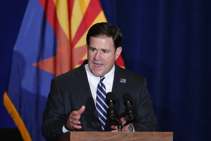 FILE - In this Tuesday, Aug. 11, 2020, file photo, Republican Arizona Gov. Doug Ducey speaks prior to Vice President Mike Pence speaking at the &quot;Latter-Day Saints for Trump&quot; Coalition launch event in Mesa, Ariz. Republicans have criticized a push by some Democrats to expand the number of seats on the U.S. Supreme Court, but their tune has changed when it comes to the highest courts at the state level. In 2016, Ducey signed into law measures expanding the number of seats on the Arizona state Supreme Court. (AP Photo/Ross D.
