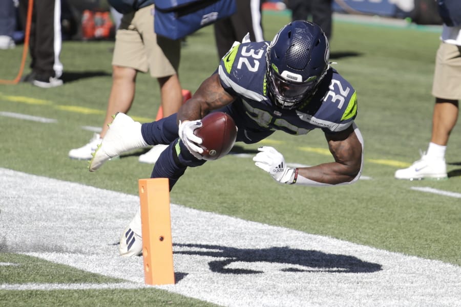 Seattle Seahawks running back Chris Carson (32) dives near the end zone during the first half of an NFL football game against the Dallas Cowboys, Sunday, Sept. 27, 2020, in Seattle. The Seahawks won 38-31.