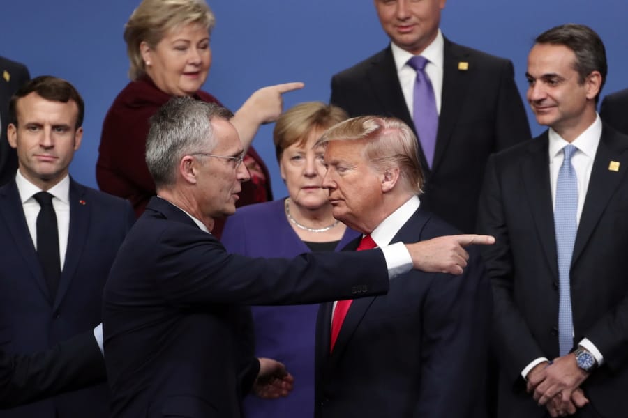FILE - In this Dec. 4, 2019, file photo, NATO Secretary General Jens Stoltenberg, front left, speaks with U.S. President Donald Trump, front right, after a group photo at a NATO leaders meeting at The Grove hotel and resort in Watford, Hertfordshire, England. There will be leaders and populations who shudder at the thought of four more years of the Donald Trump administration and those whose consternation is tied to his potential defeat, and a U.S. government led by a President Joe Biden.