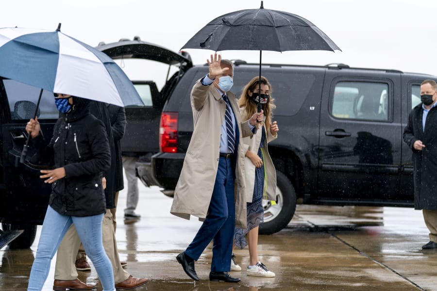 Democratic presidential candidate former Vice President Joe Biden, accompanied by his granddaughter Natalie Biden, right, boards his campaign plane at New Castle Airport in New Castle, Del., Thursday, Oct. 29, 2020, to travel to Florida for drive-in rallies.