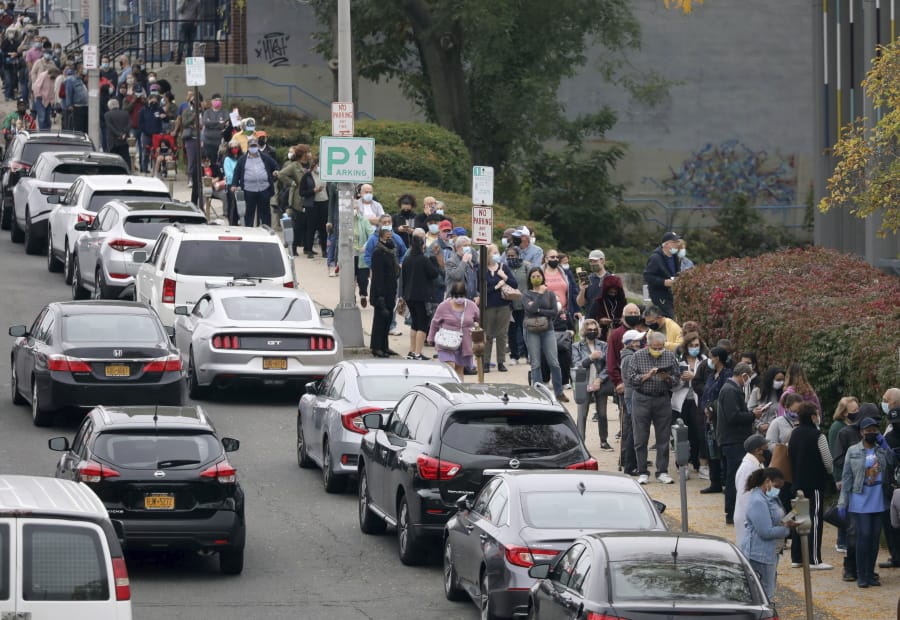 Voters line up in front of the Yonkers Public Library in Yonkers, N.Y., on Saturday, Oct. 24, 2020 as the first day of early voting in the presidential election begins across New York state.