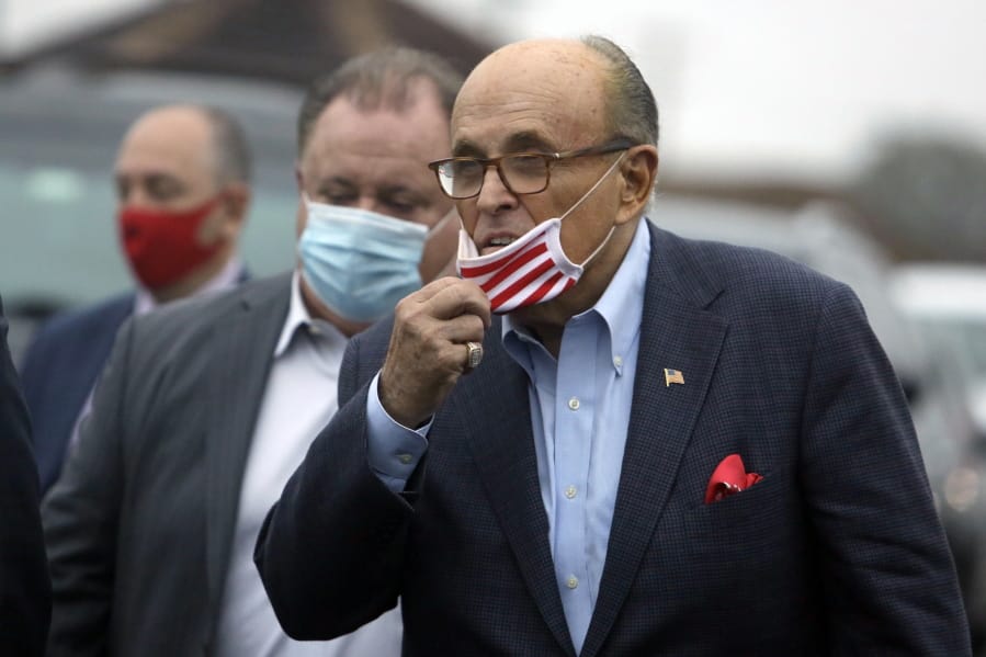 Former New York Mayor Rudy Giuliani lowers his face mask as he approaches supporters of President Donald Trump Monday, Oct. 12, 2020 during a Columbus Day gathering at a Trump campaign field office in Philadelphia.